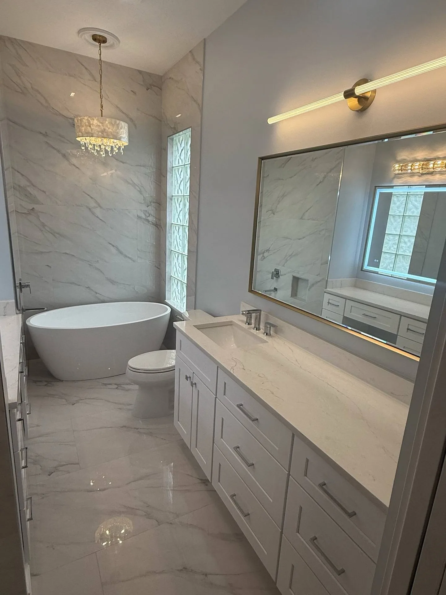 Bathroom renovation with freestanding tub, tiled shower, and vanity