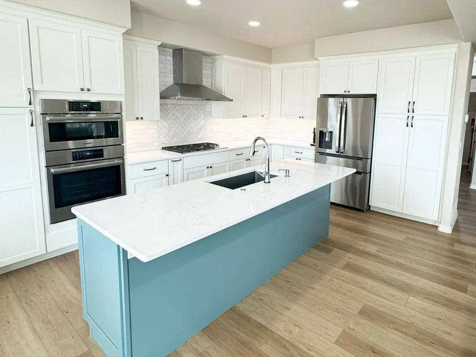 White cabinetry and blue kitchen island